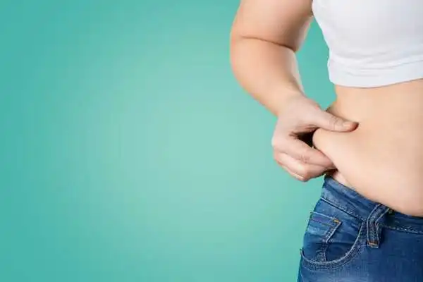 Image of woman pinching her love handles to show weight gain Sedgley Park